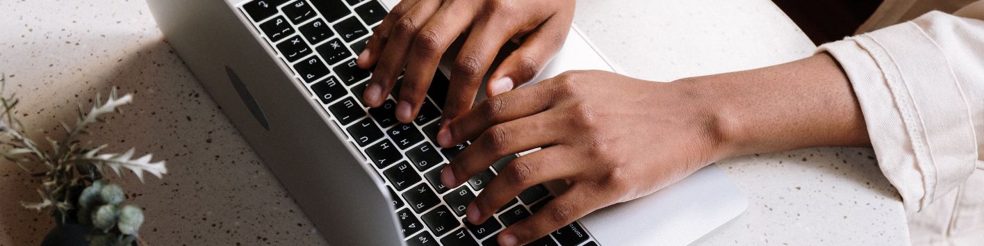 Zwei Hände liegen auf einer Computertastatur und beginnen gleich zu tippen.