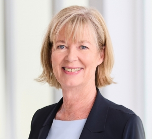 Portraitaufnahme einer Frau mit hellblauem T-Shirt und dunkelblauem Blazer