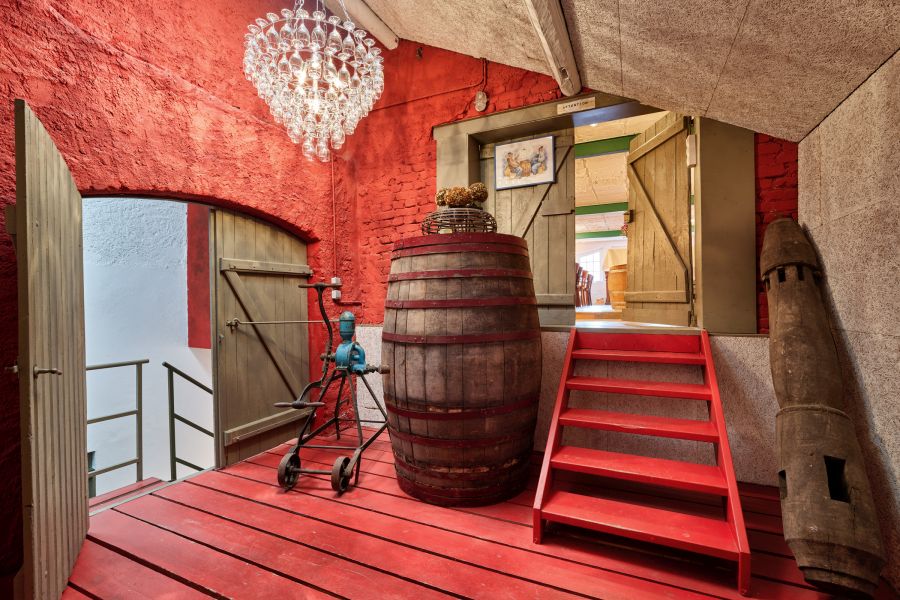 Innenraum mit rotem Holzboden, roter Wand und roter Innentreppe zum Nachbarraum