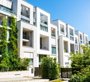 Blick auf Mehrfamilienhäuser mit Balkonen und Grünpflanzen.