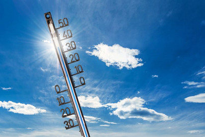Thermometer, das 30 Grad anzeigt vor strahlend blauem Himmel