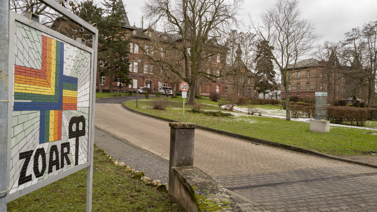 Blick auf ein Schild mit dem Schriftzug "ZOAR" und ein Gebäude.