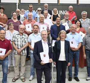 Gruppe von Menschen, die ein Dokument in Händen halten.