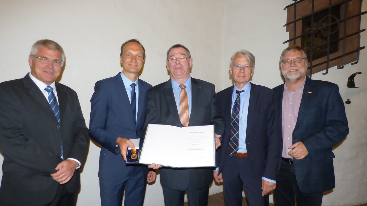 Gruppenfoto mit einer Urkundenüberreichung