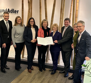 Finanz- und Bauministerin Doris Ahnen und ISB-Vorstandsmitglied Sandra Baumbach überreichen Förderbescheid an Bauherrengemeinschaft Bohr und Adler