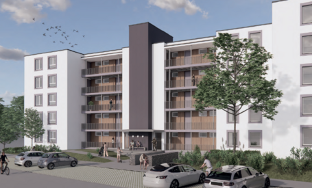 Perspektive der Eingangsseite, weiße Fassade mit zurückgesetzten Laubengang in Holz und Aufzugsturm mit dunklem Anstrich
